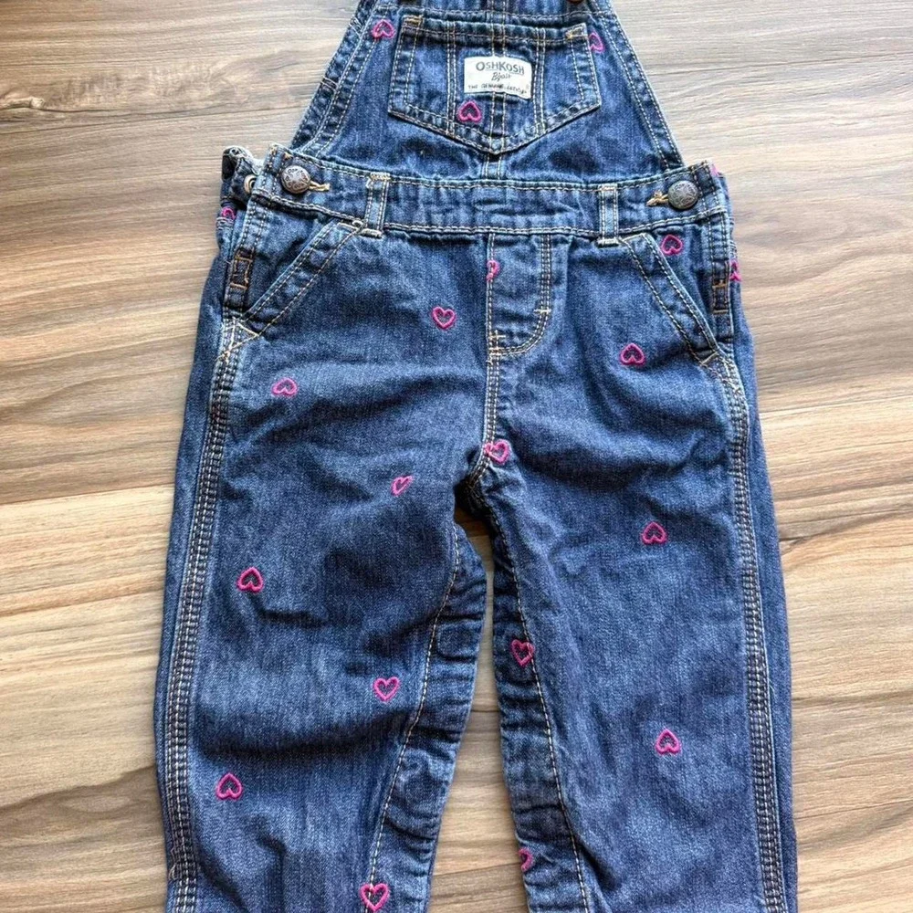 OshKosh B'gosh blue denim overalls with pink heart embroidery